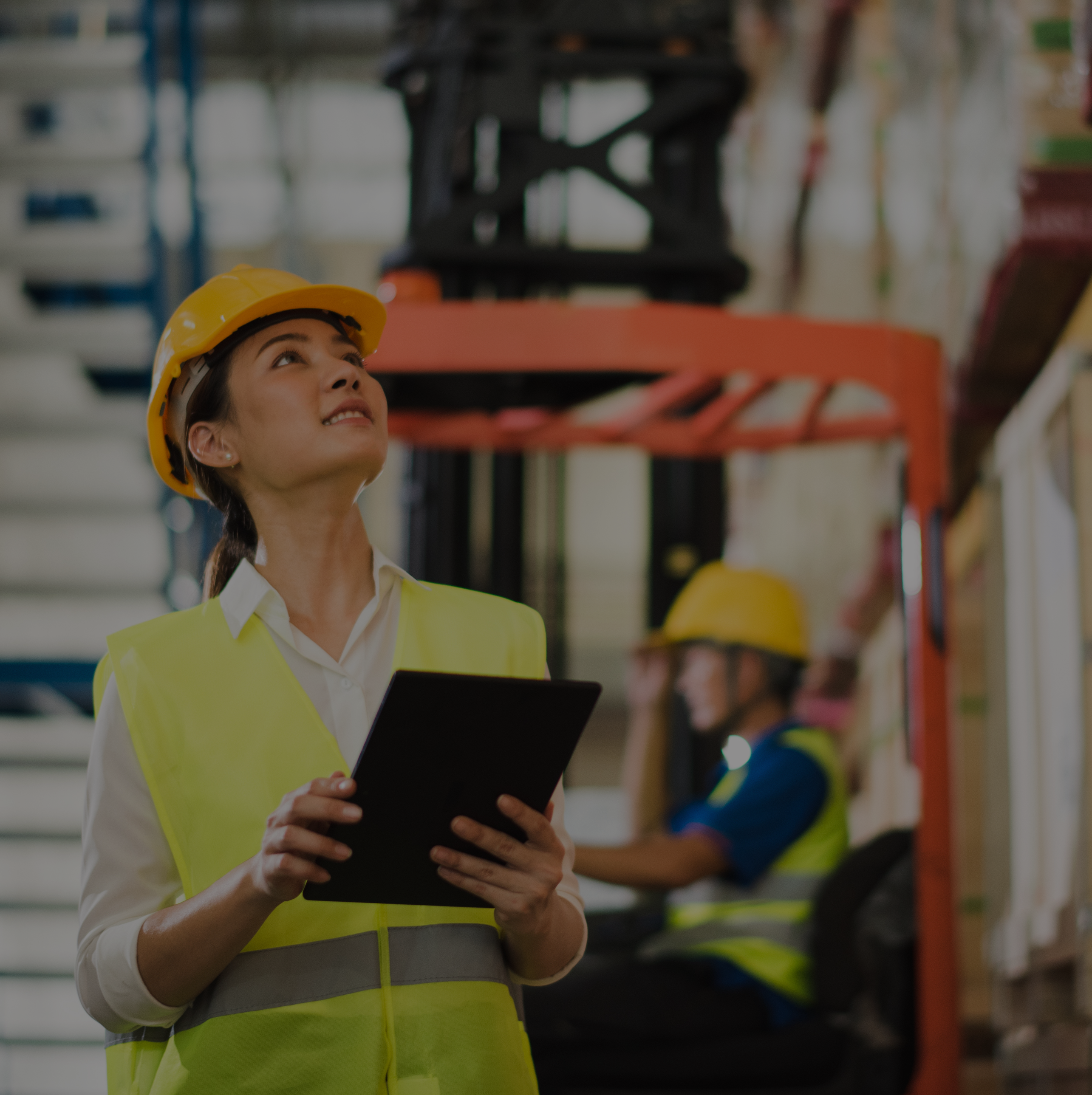 Female supplier in yellow safety vest in a warehouse