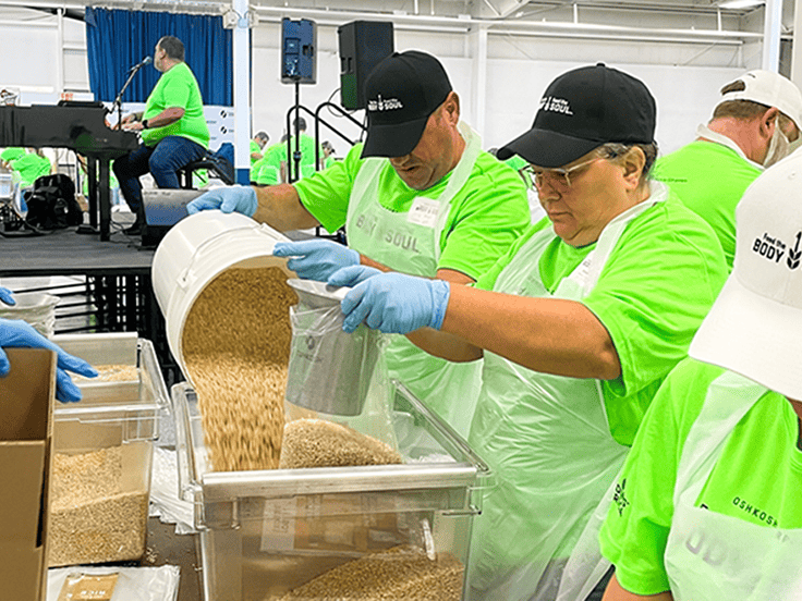 Volunteers participating in the annual Oshkosh Corporation Feed the Body, Feed the Soul packing event in partnership with Feeding America