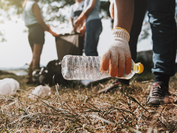 Hand picking up trash outside