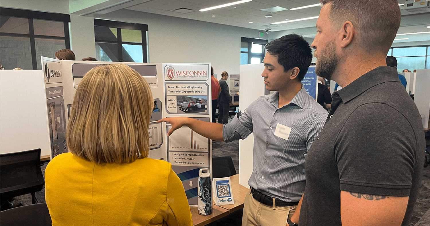  Intern showcasing a posterboard of information regarding their internship accomplishments to leaders at the organization