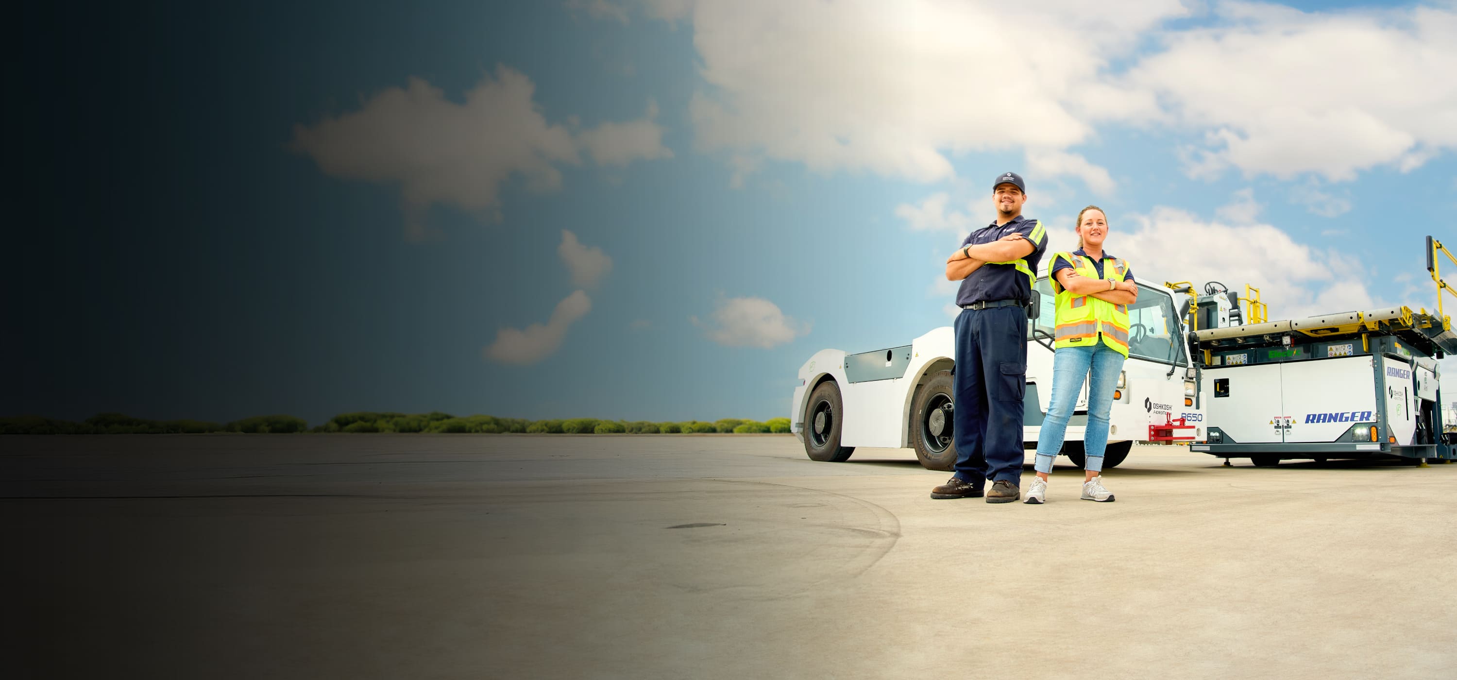 Oshkosh AeroTech team members outside at an airport in front of products