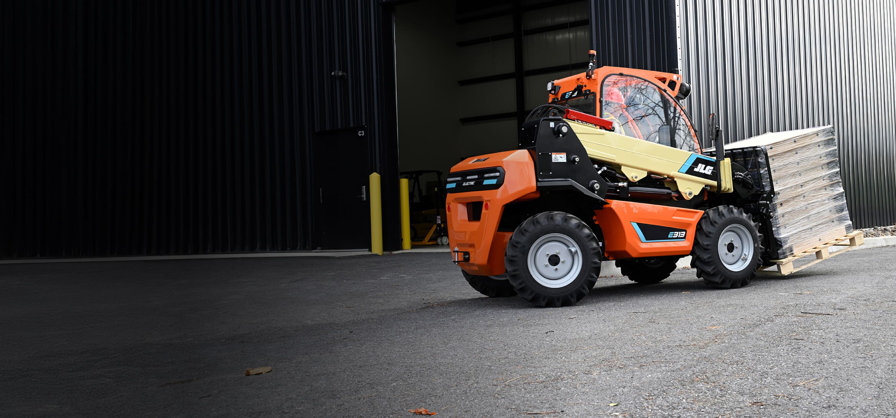 JLG electric telehandler operating outside of a building