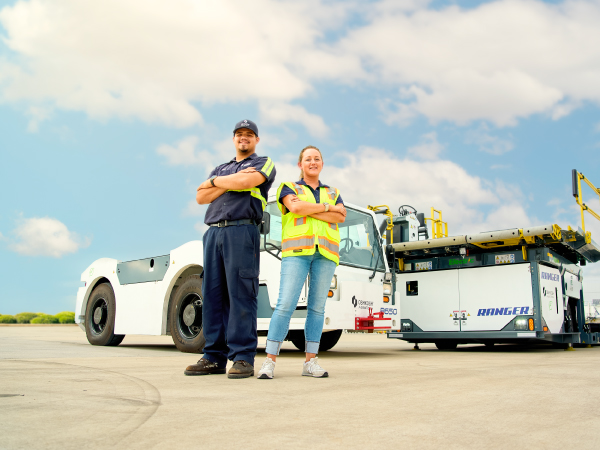 Oshkosh AeroTech team members standing in front of Oshkosh AeroTech product at an airport