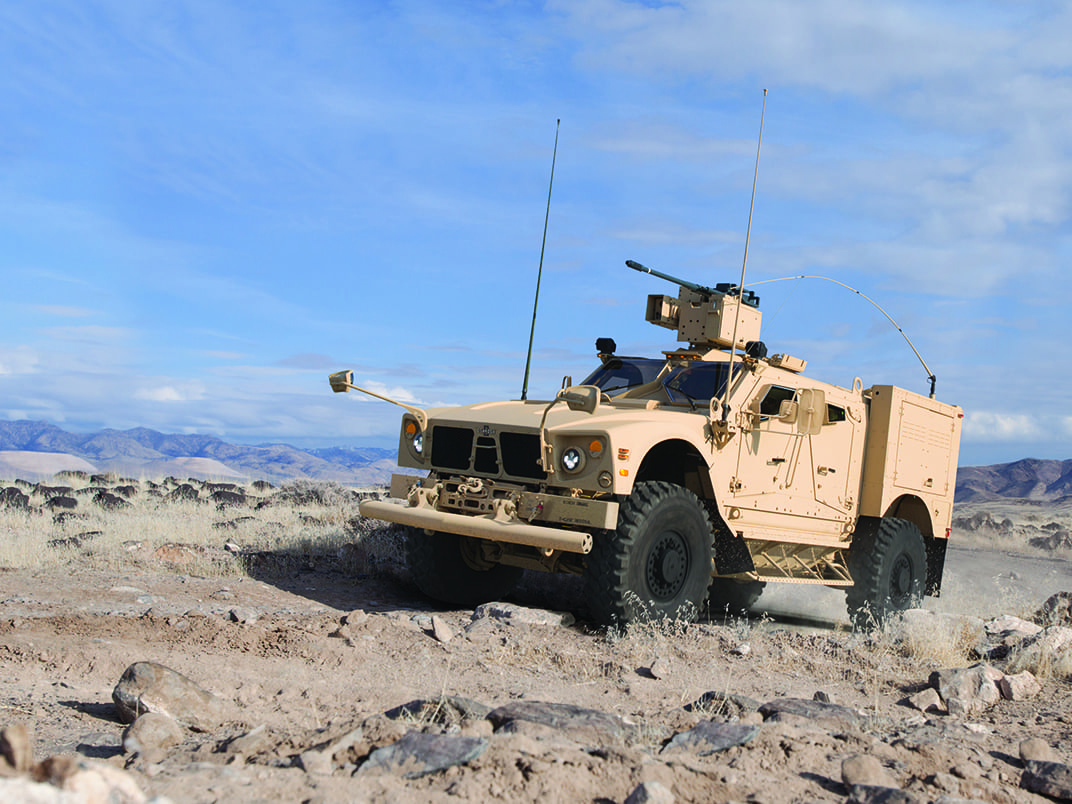 Cream MATV outside driving on rough terrain