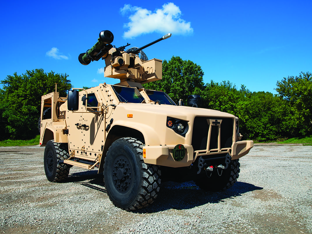 Cream LATV Oshkosh Defense vehicle parked outside on dirt on a sunny day