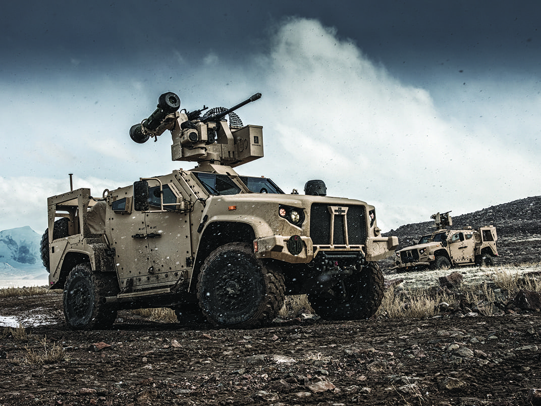 Cream Oshkosh JLTV positioned outside on dirt