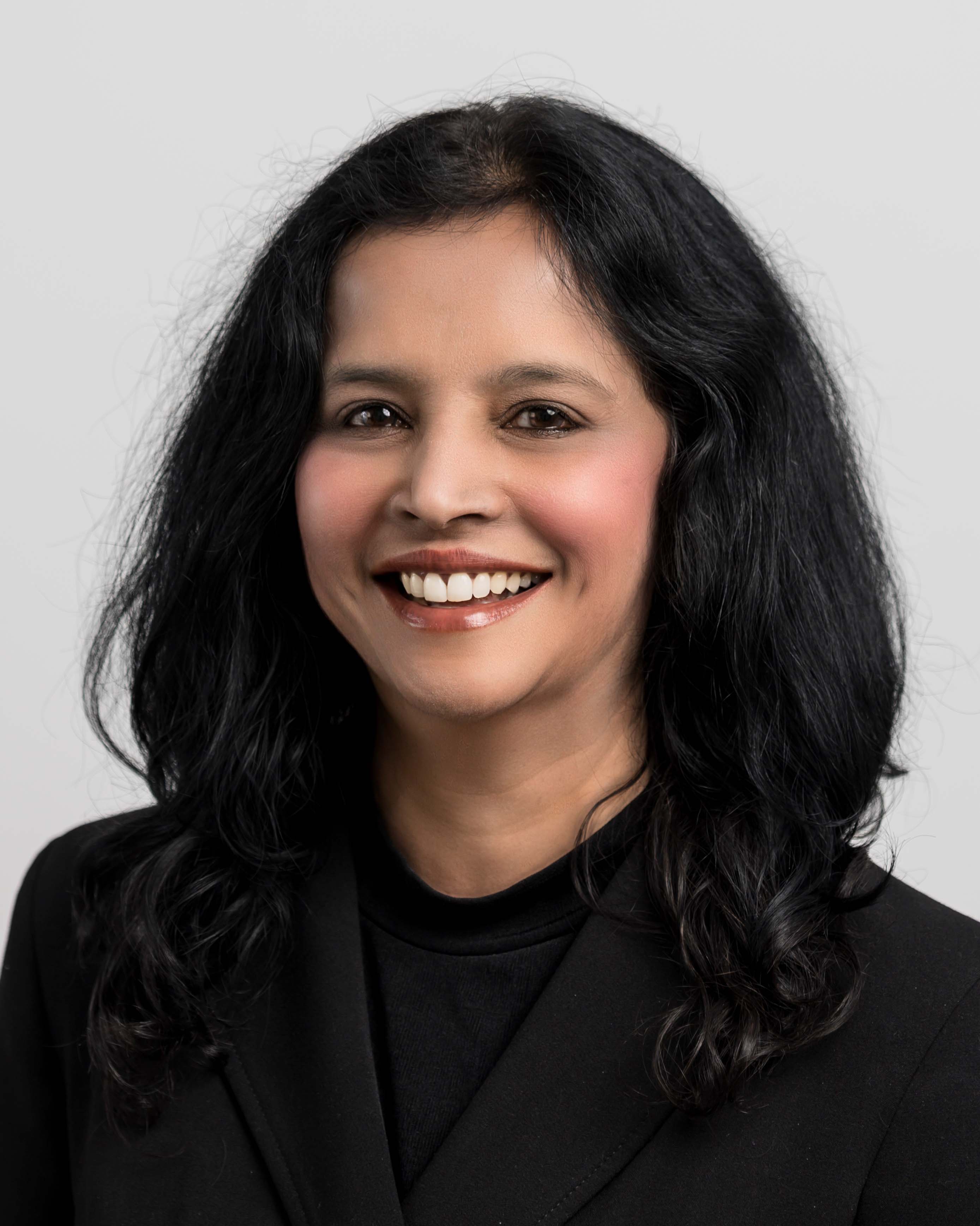 Female Jay Iyengar wearing a black top and smiling 