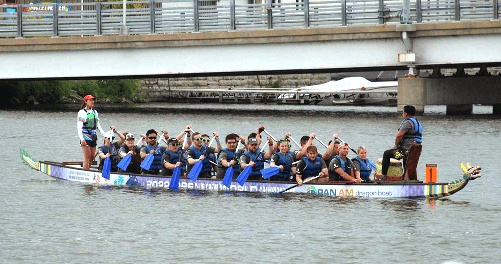  Oshkosh team members in a Dragonboat race on a body of water